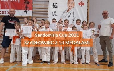 W tle zdjęcie zwycięzców z sensejem Mariuszem Szymkiewiczem i Zbigniewem Kozłowskim. Dodany naspis Senomidia Cup 2021, 10 medali dla Szydłowca