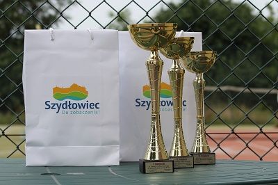 Zdjęcie przedstawia nagrody i puchary dla zwyciezców Turnieju Tenisa Ziemnego o Puchar Burmistrza Szydłowca.